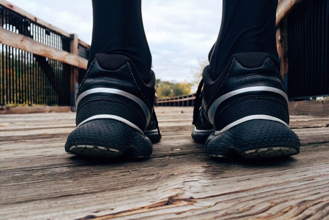 Zbliżenie na buty do biegania na drewnianym moście podczas treningu Zbliżenie na buty do biegania na drewnianym moście podczas treningu