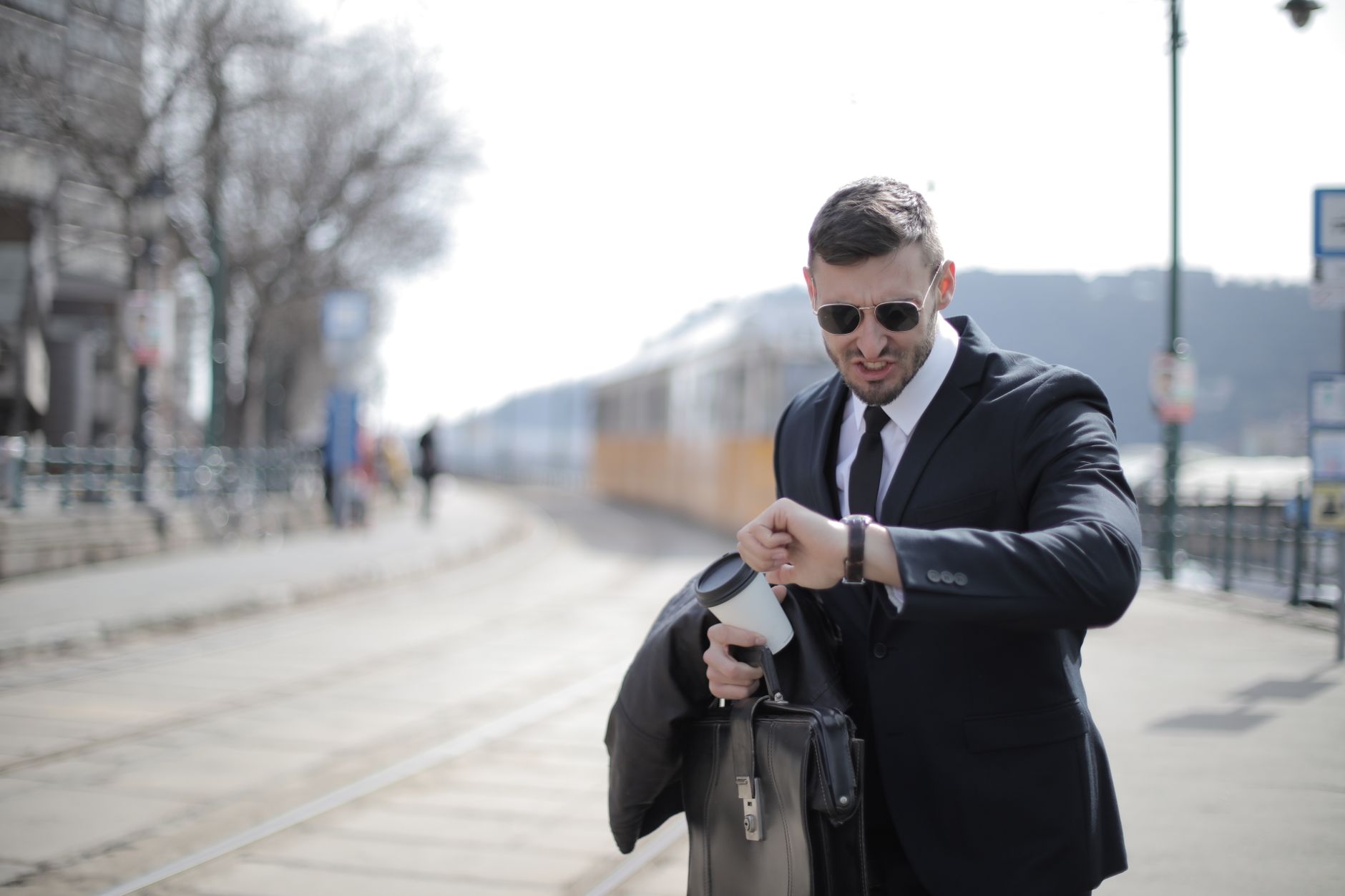 Biznesmen w garniturze sprawdza zegarek, spiesząc się po mieście