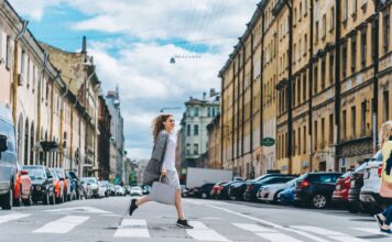 Biegacze w podróży służbowej: szybkie patenty na trening między spotkaniami w hotelu Pewna siebie kobieta przechodzi przez pasy w tętniącym życiem mieście